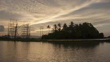 meraviglioso tramonto di una torre elettrica di architettura costruita a metà e circondata da un albero di cocco video