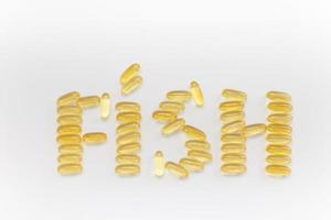 Omega 3 capsules in the form of the word fish, Vitamin D on white background. Close-up, top view, copy space for your text. photo