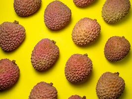 Lychee on the table. Chinese plum on a yellow background. Ripe fruit from Asia. photo