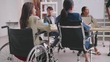 un dipendente disabile dell'azienda è in grado di lavorare felicemente con i colleghi in ufficio. un gruppo di esperti di marketing sta discutendo durante la riunione. video