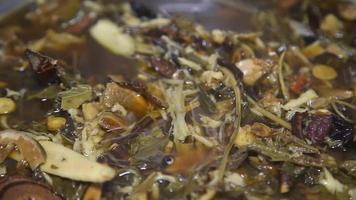 chinese kruiden chinese kruidengeneeskunde afgeleid van de natuur bijvoorbeeld paddenstoelen, wortels, bladeren in kookpot in de pot. video