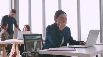 A young company employee is feeling tired while sitting at work for a long time. video