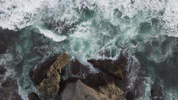 vue aérienne de haut en bas des vagues géantes de l'océan qui se brisent et écument sur la plage de corail video