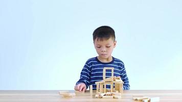 Asian boy playing with a wooden puzzle video