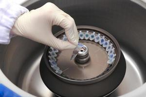 Scientist loading a sample to centrifuge photo