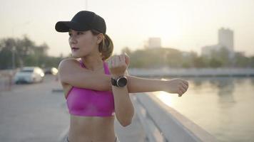 Young sportive woman doing stretching exercises. Girl resting after exercise outdoors. Athletic woman stretching against a tree. fit sportswoman doing warming up exercises video