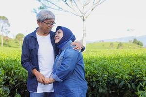 Asian Elderly couple. Joyful nice elderly couple smiling while being in a great mood at tea plantation. photo