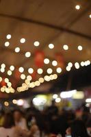 Blur background of food market with hanging bulb lamps photo