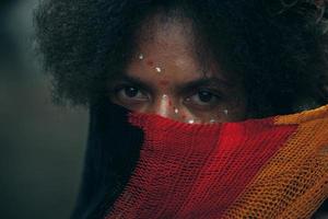 wamena, papua, indonesia, 01 de junio de 2022 primer plano de una joven que cubre la mitad de la cara con ropa colorida, tribu dani de papua. foto