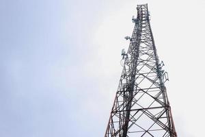torre de satélite aislada en el cielo azul de nubes blancas. torre de transmisión de señales telefónicas y de televisión. torre de radiocomunicaciones. foto
