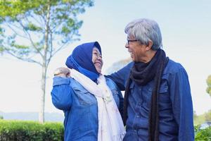 Happy elderly couple laughing each other at tea plantation. photo