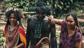 wamena, papúa, indonesia, 01 de junio de 2022 familia papuana de la tribu dani cazando peces juntos en el río. foto