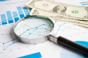 Magnifying glass with US dollar banknotes on charts graphs paper. Financial development, Banking Account, Statistics, Investment Analytic research data economy. photo