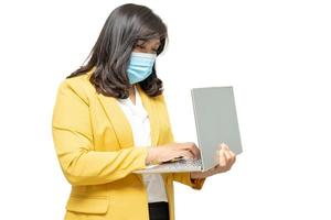 Business asian lady wearing face shield and face mask holding laptop isolated on white background with clipping path. photo