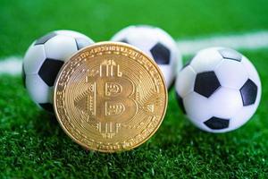 bitcoin de oro con balón de fútbol o fútbol, criptomoneda utilizada en apuestas deportivas en línea. foto