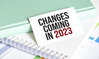 change is coming text write on paper and charts on wooden background photo