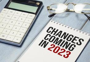 change is coming text write on paper and calculator on wooden background photo