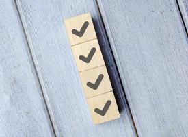 Checklist Survey and assessment concept, human hand putting cube wood with Check mark icon on wooden blocks, photo