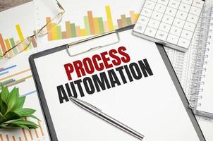 PROCESS AUTOMATION text on file folder and charts on wooden background photo