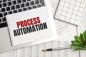 PROCESS AUTOMATION text on notepad and laptop, calculator and pen photo