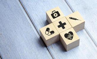 concepto de seguro médico, bloques de madera con icono médico sanitario, fondo azul foto