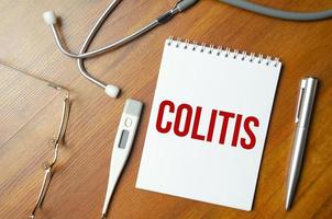 colitis word and stethoscope on wooden background photo