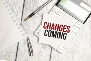 change is coming text on sticker with calculator, glasses and magnifier photo