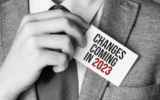 change is coming in 2023 text write on business card photo