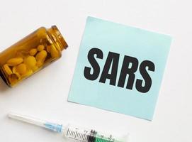 SARS word on sheet of paper and pills photo
