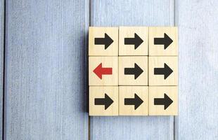Wooden Block With Red Arrow Facing The Opposite Direction Black Arrow photo