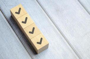 Checklist concept, Check mark on wooden blocks, blue background with copy space photo