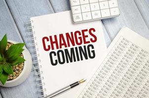 change is coming text write on paper and calculator on wooden background photo