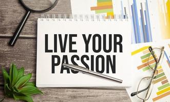 LIVE YOUR PASSION text on notepad and magnifier photo
