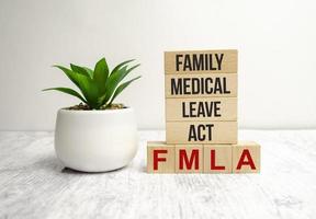 FMLA family medical leave act symbol. Concept words FMLA family medical leave act on wooden blocks photo