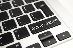 Close up button with the words ask an Expert, on a black keyboard. Creative background, copy space. photo