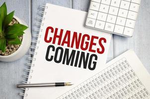 change is coming text write on paper and calculator on wooden background photo