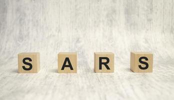 sars word on wooden cubes and wooden background. Epidemic concept photo