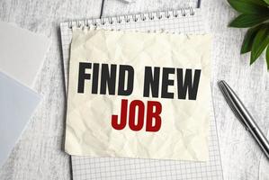 Find New Job word on sheet of paper on wooden background photo