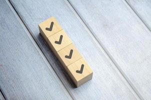 Checklist concept, Check mark on wooden blocks, blue background with copy space photo