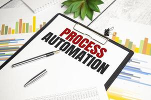 PROCESS AUTOMATION text on file folder and charts on wooden background photo