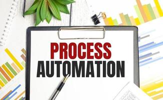 PROCESS AUTOMATION text on file folder and charts on wooden background photo