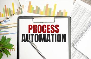 PROCESS AUTOMATION text on file folder and charts on wooden background photo