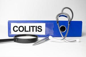 colitis word on blue file folder and stethoscope on white background photo