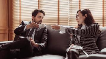 pareja de negocios trabajando juntos y tomando café en la oficina. dos empresarios tomando café y discutiendo sobre el proyecto. concepto de negocio y trabajo. foto