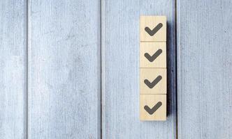 Checklist concept, Check mark on wooden blocks, blue background with copy space photo