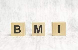 la palabra bmi está escrita en cubos de madera sobre fondo blanco foto