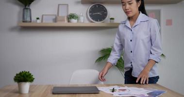 portrait d'une femme d'affaires asiatique fatiguée travaillant à domicile à son bureau ouvre un ordinateur portable dans le bureau à domicile. une femme ouvre un cahier et commence à taper écrit des e-mails surfe sur Internet.