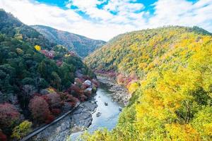 montañas de hojas coloridas y río katsura en arashiyama, hito del paisaje y popular para las atracciones turísticas en kyoto, japón. otoño temporada de otoño, vacaciones, vacaciones y turismo concepto foto