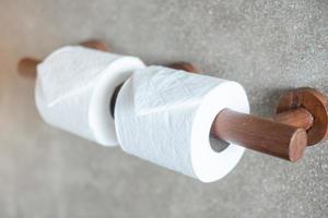Woman hand pulling toilet paper in restroom. Cleaning, Lifestyle and personal hygiene concept photo