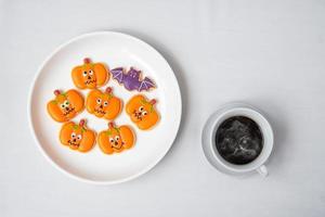taza de café caliente con divertidas galletas de halloween. feliz día de halloween, truco o amenaza, hola octubre, otoño otoño, tradicional, concepto de fiesta y vacaciones foto